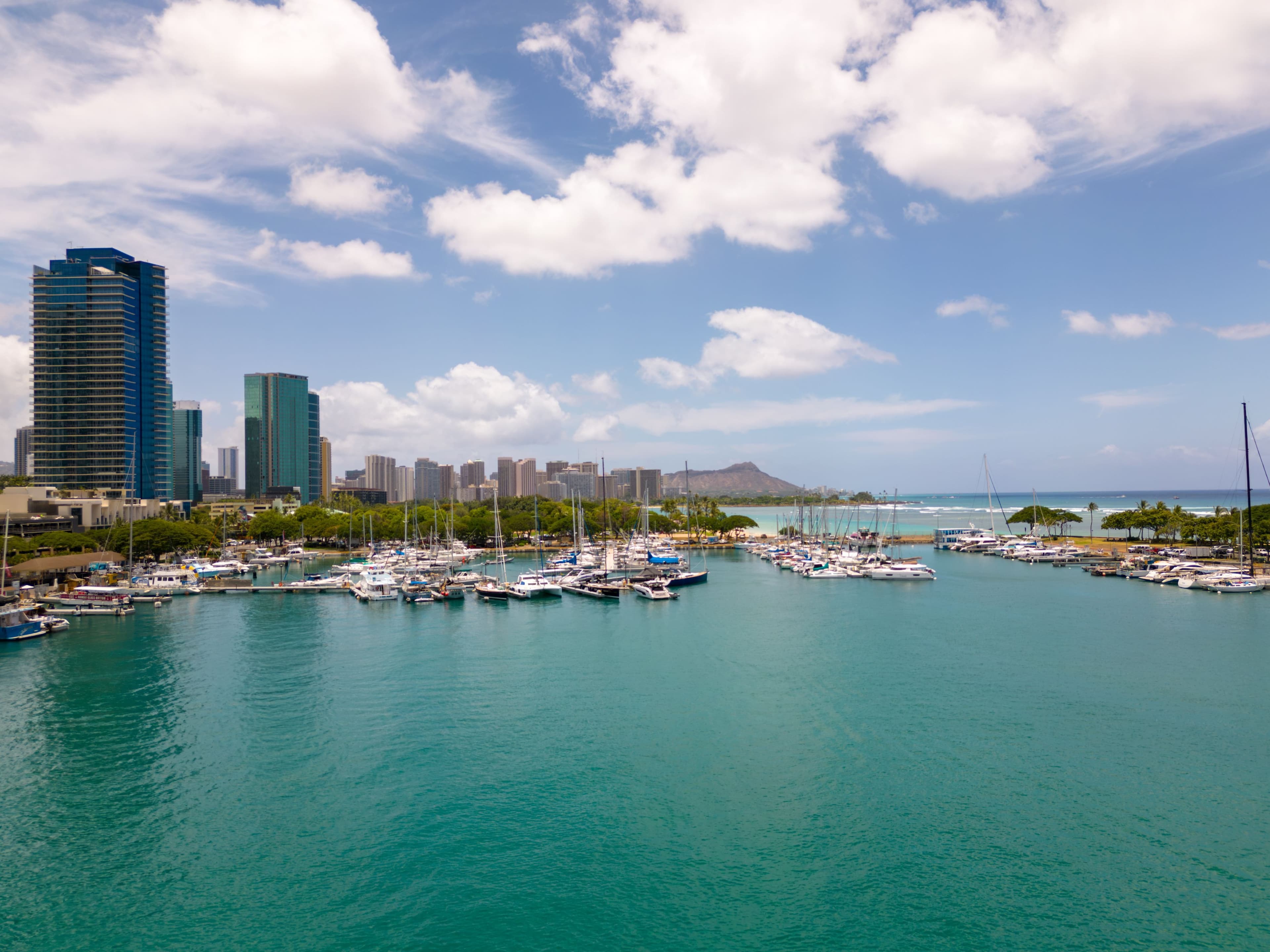 Yachts moored at Keehi Boat Harbor with the Honolulu skyline and Diamond Head beyond